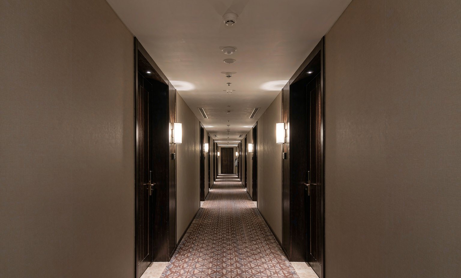Hotel corridor ceiling fitted with interconnected smoke detectors